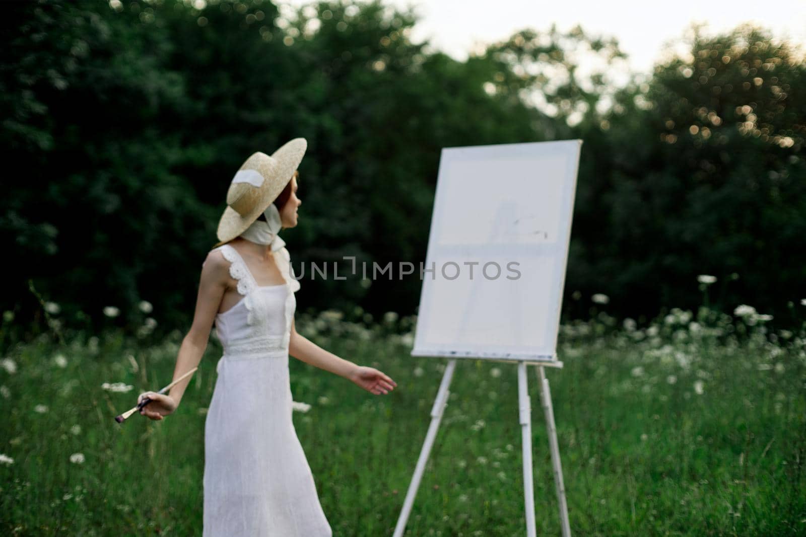 pretty woman in white dress outdoors drawing art creative. High quality photo