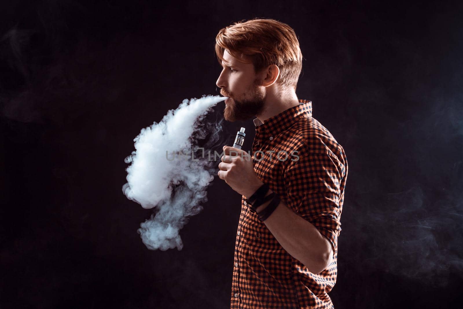 young man smoking electronic cigarette by nazarovsergey