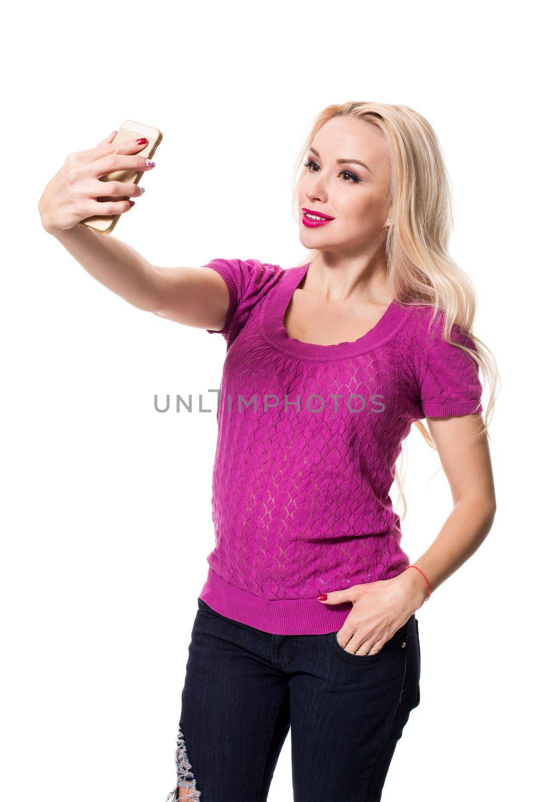 Young blonde doing selfie on isolated white background. Selfie time. Young woman in a lilac blouse