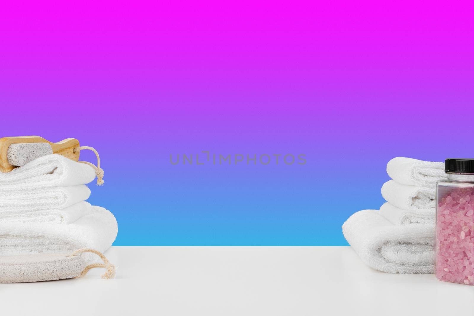 Bath towels and spa salt on white table, close up