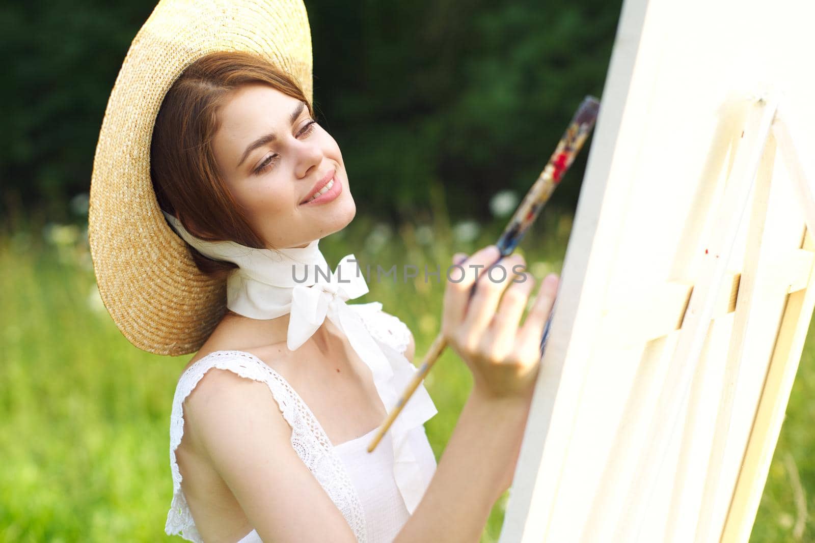 Woman in white dress artist paints on nature palette creative. High quality photo