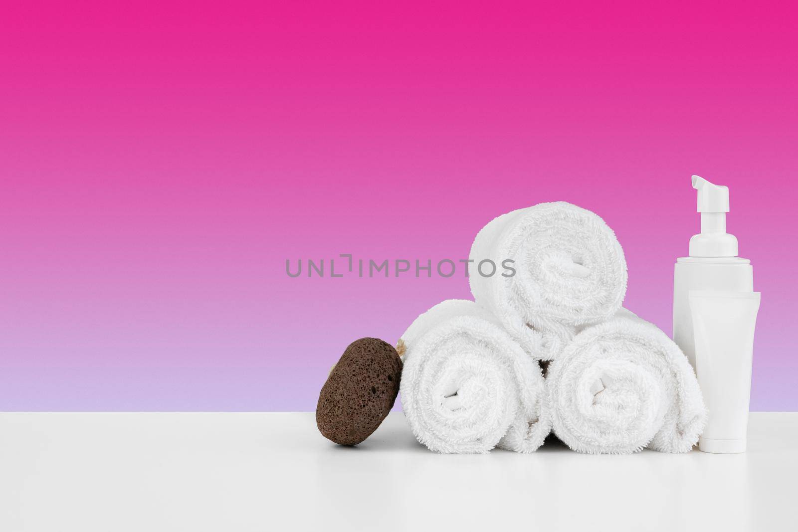Spa still life with stacked towels and spa stone, front view