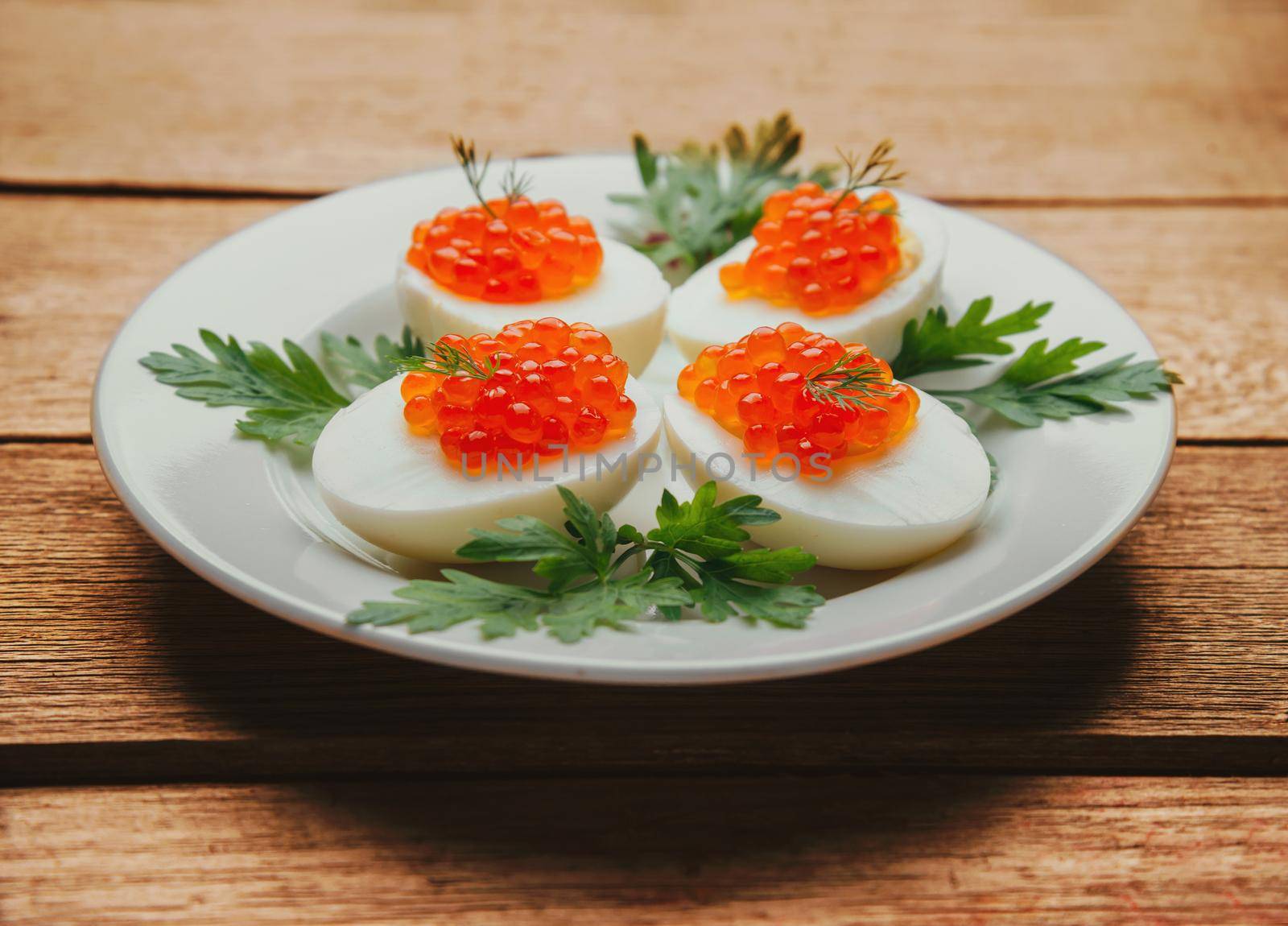 Boiled eggs half with red salmon caviar by alexAleksei