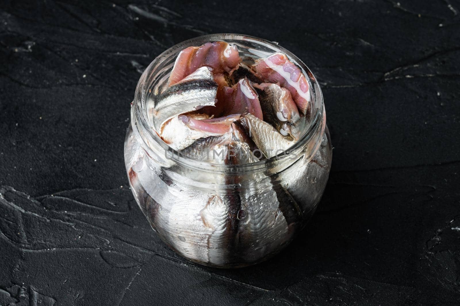 Canned Anchovies set, in glass jar, on black background, with copyspace and space for text