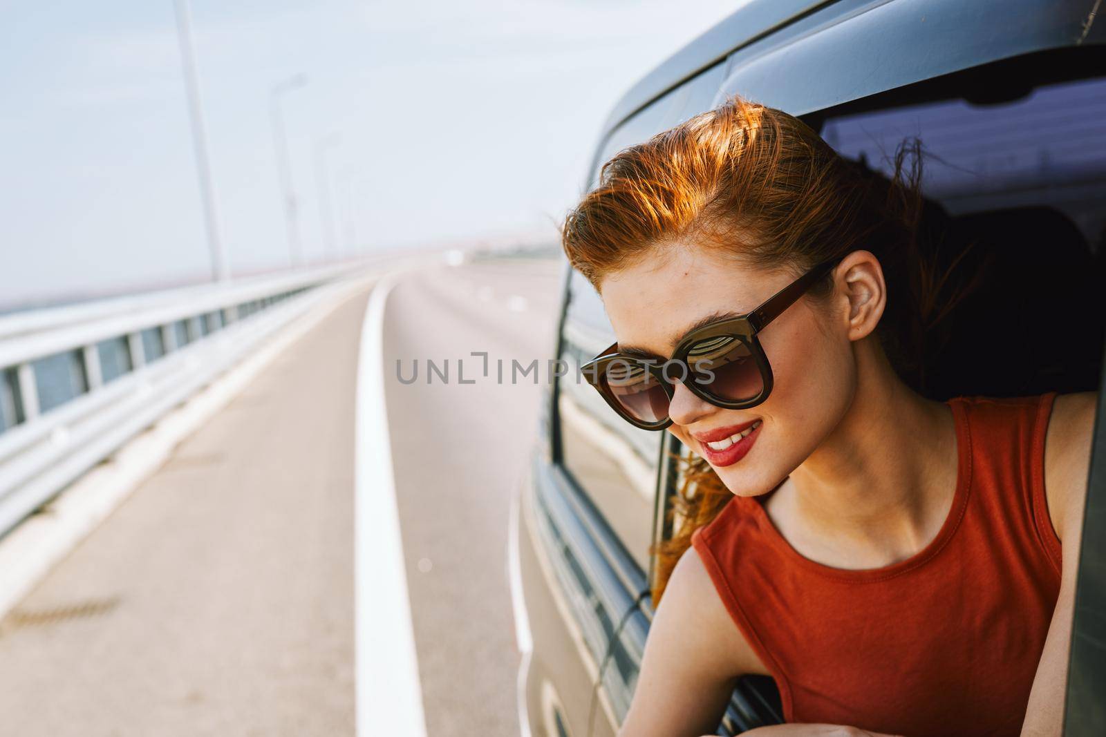 woman looking out of car window wearing sunglasses travel lifestyle. High quality photo