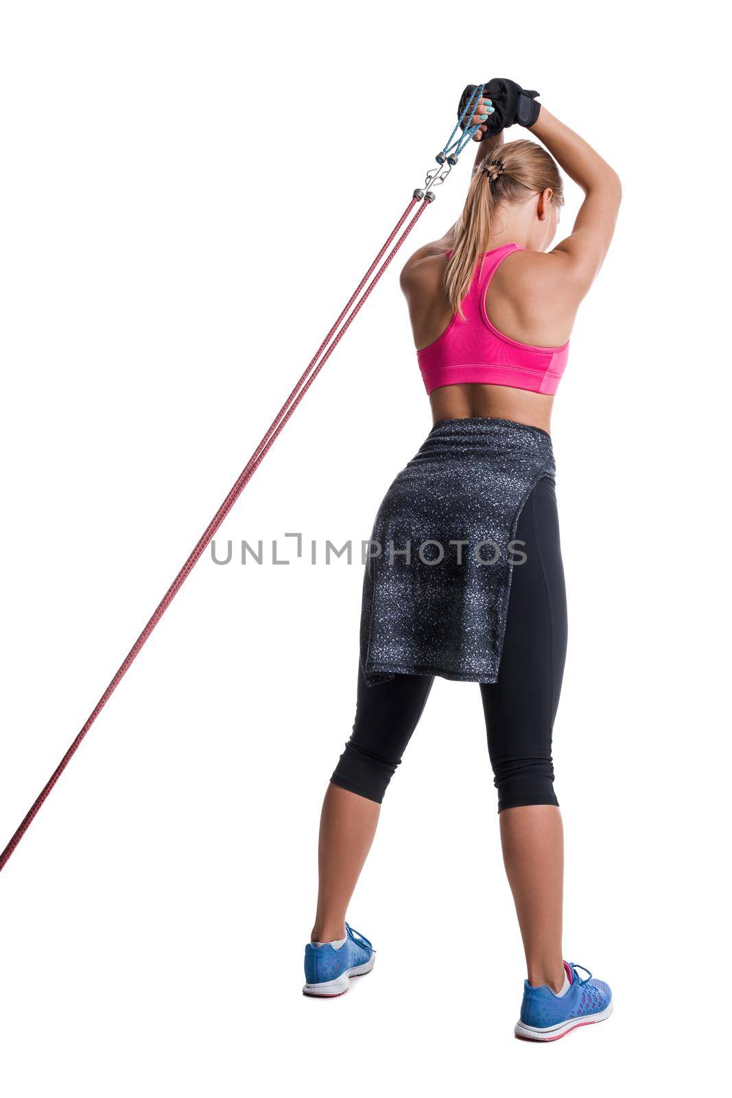 Strong woman using a resistance band in her exercise routine. Young woman performs fitness exercises on white background. Woman with beautiful slim healthy body posing in studio.