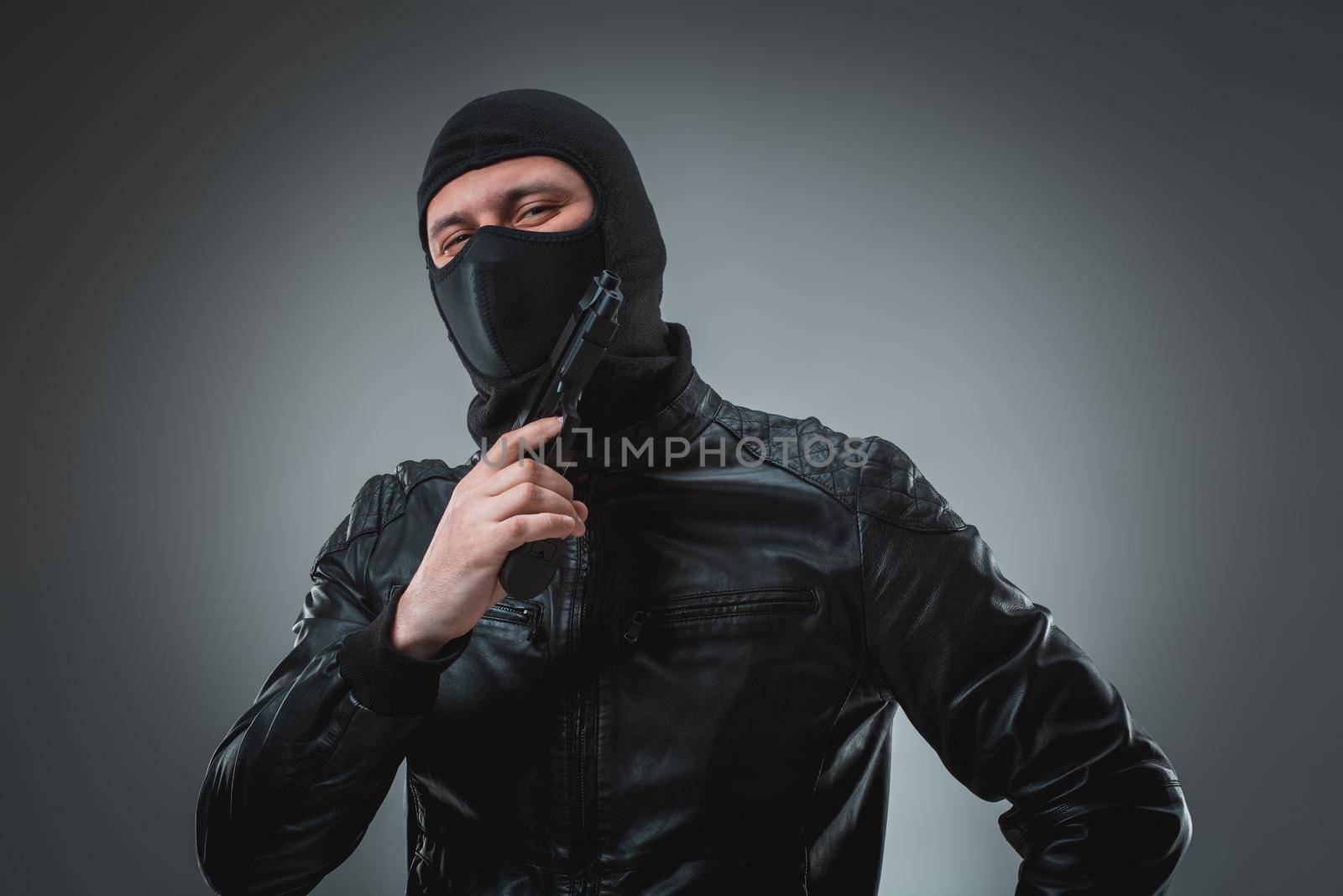 Robber with a gun, studio shot by nazarovsergey