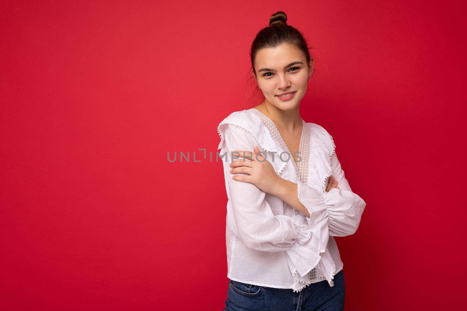Photo portrait of beautiful happy funny young brunette woman in stylish white blouse. Sexy carefree female person posing isolated on red background. Positive model shows sincere emotions.