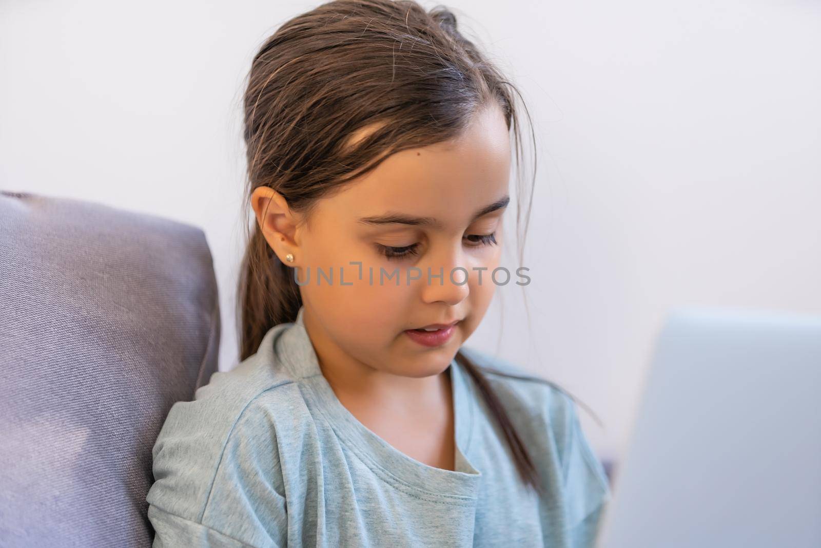 Cute little girl using laptop at home. Education, online study, home studying, distance learning, schoolgirl children lifestyle concept by Andelov13