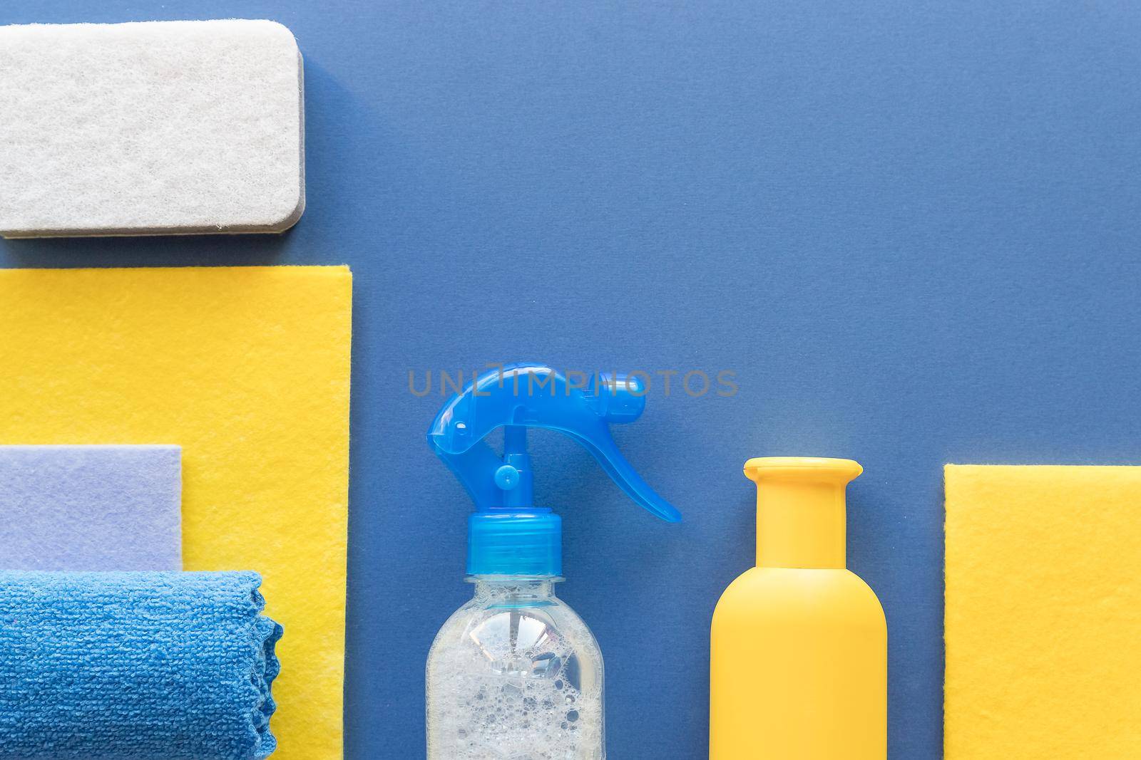 House cleaning and housekeeping concept on blue background. Detergents for cleaning or disinfecting the room.
