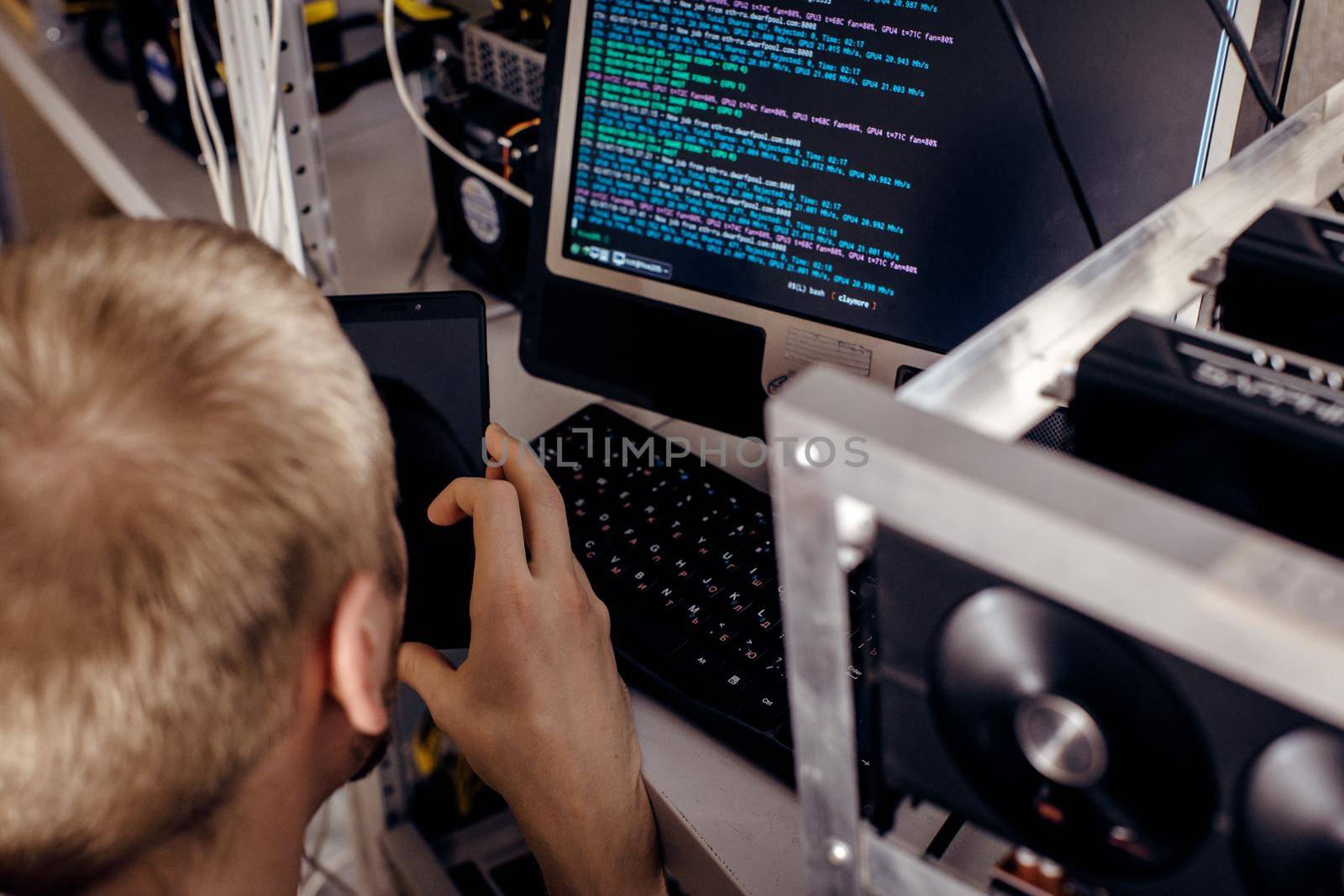 A man holds a tablet in the hands next to computing a computer