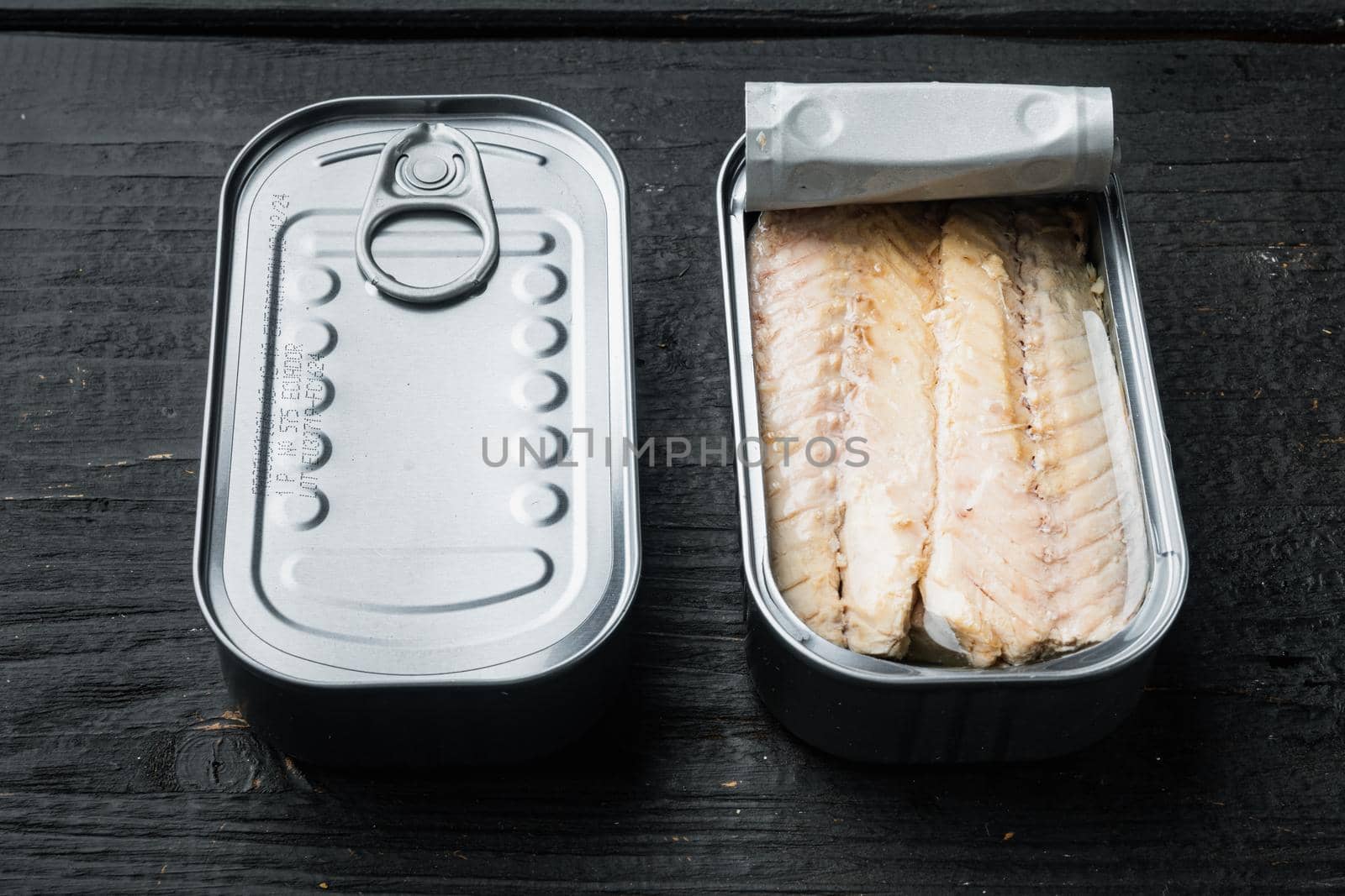 Canned Mackerel Fillets in Tin set, in tin can, on black wooden table background
