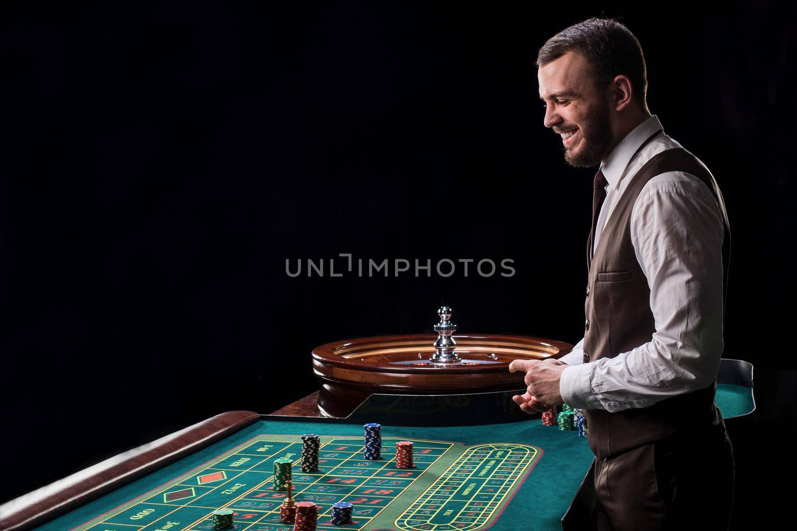 Croupier behind gambling table in a casino. by nazarovsergey