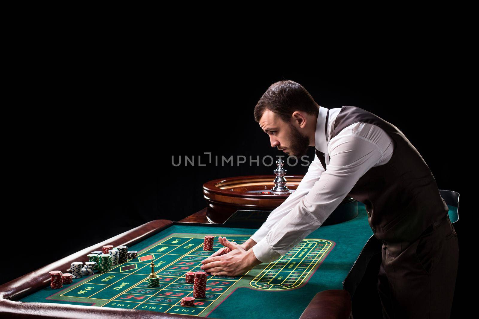 Croupier behind gambling table in a casino. by nazarovsergey