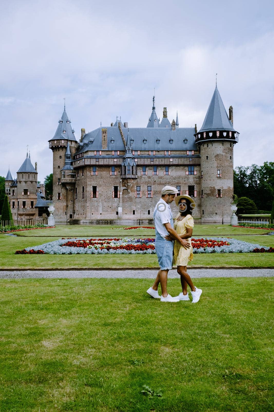 Castle de Haar Utrecht, couple men and woman mid age European and Asian visit De Haar Castle in Dutch Kasteel de Haar is located in Utrecht Netherlands during Spring with flowers in the garden