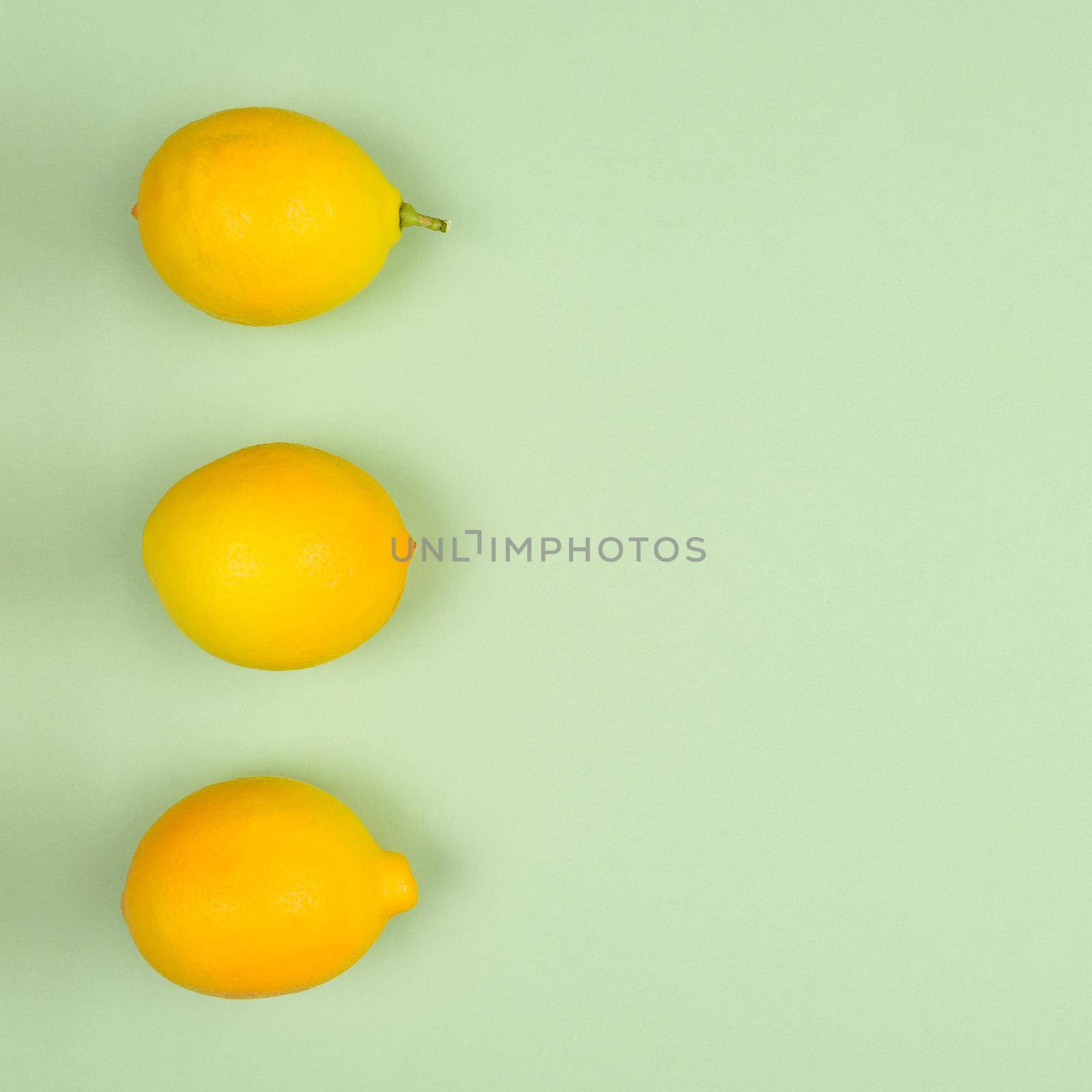 Top view flat lay fresh picked lemons on a pastel green background. 