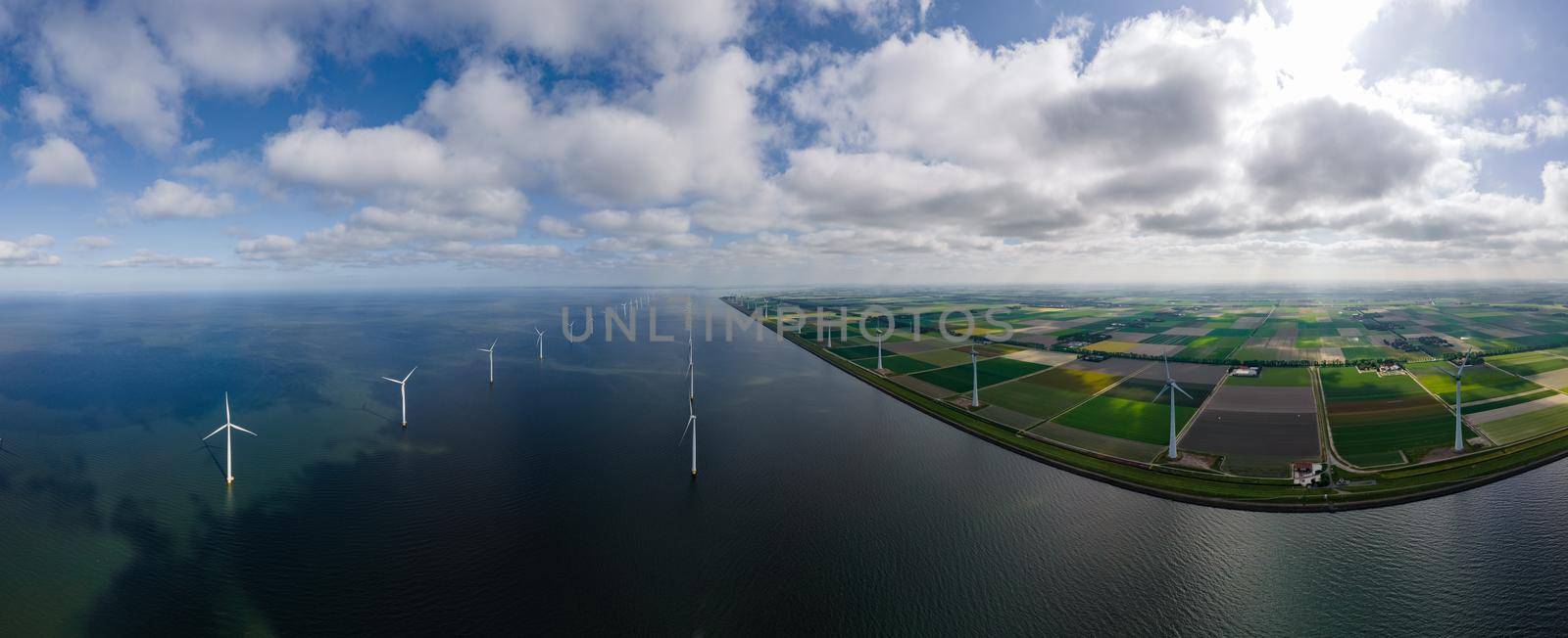 offshore windmill park with clouds and a blue sky, windmill park in the ocean drone aerial view with wind turbine Flevoland Netherlands Ijsselmeer by fokkebok