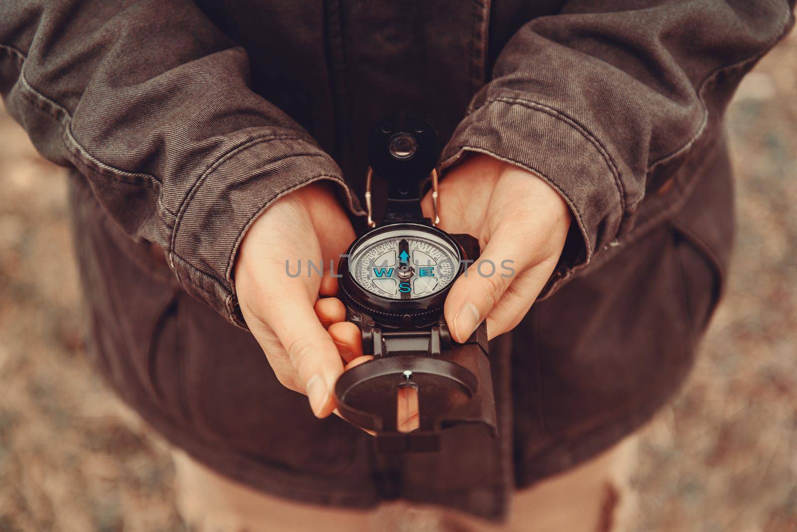 Hiker woman holding a compass on nature