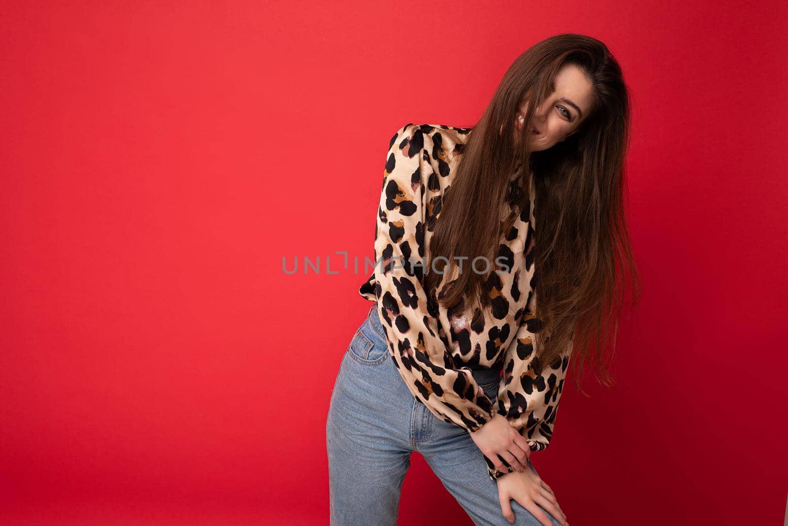 Close-up portrait of young nice-looking attractive lovely glamorous brunet woman wearing leopard blouse isolated on red color background with free space.