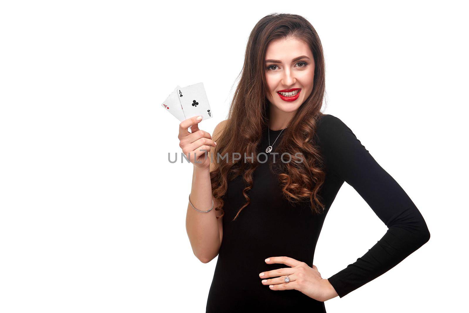 Sexy curly hair brunette in black dress posing with two aces cards in her hands, poker concept isolation on white background. winning combination