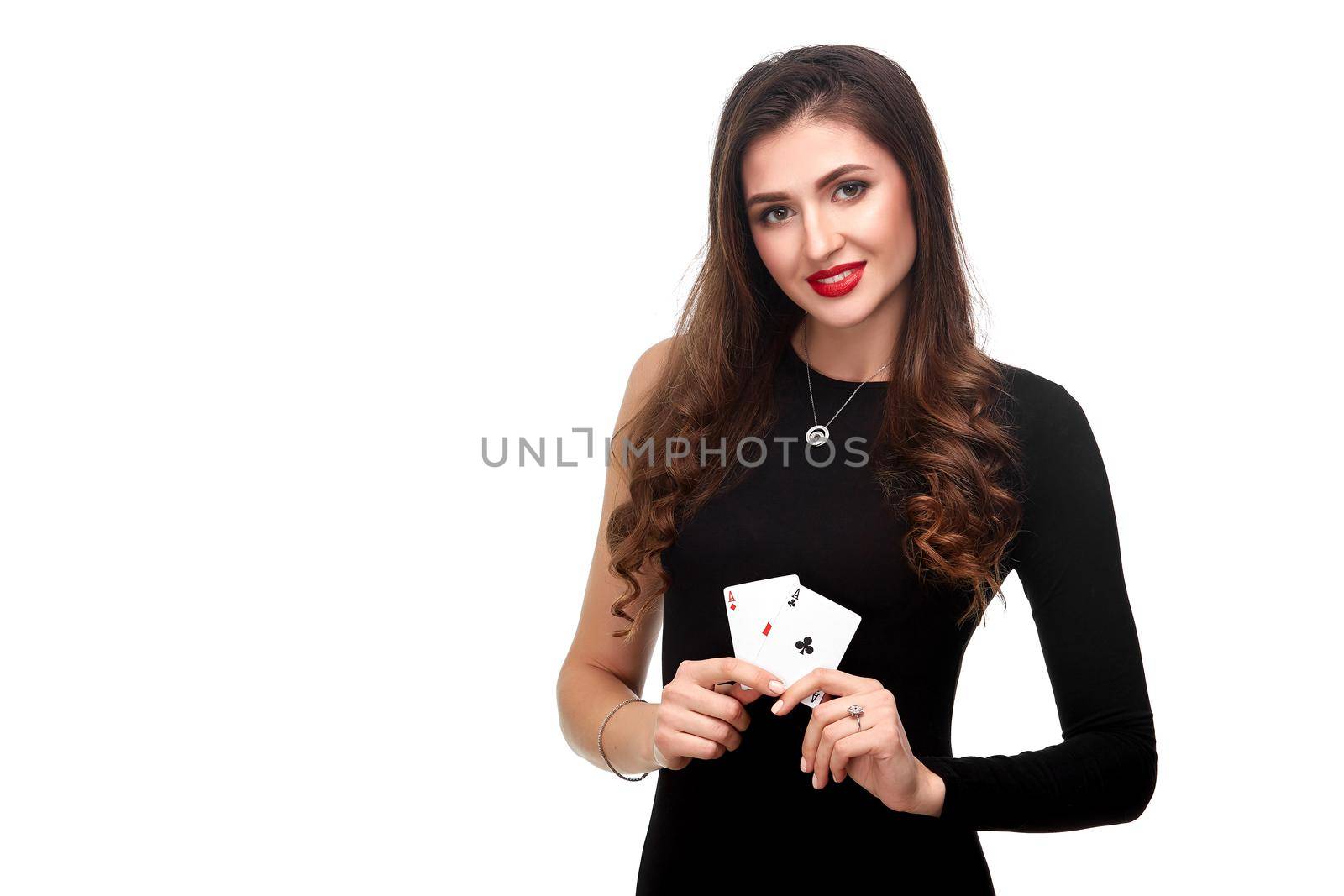 Sexy curly hair brunette in black dress posing with two aces cards in her hands, poker concept isolation on white background. winning combination