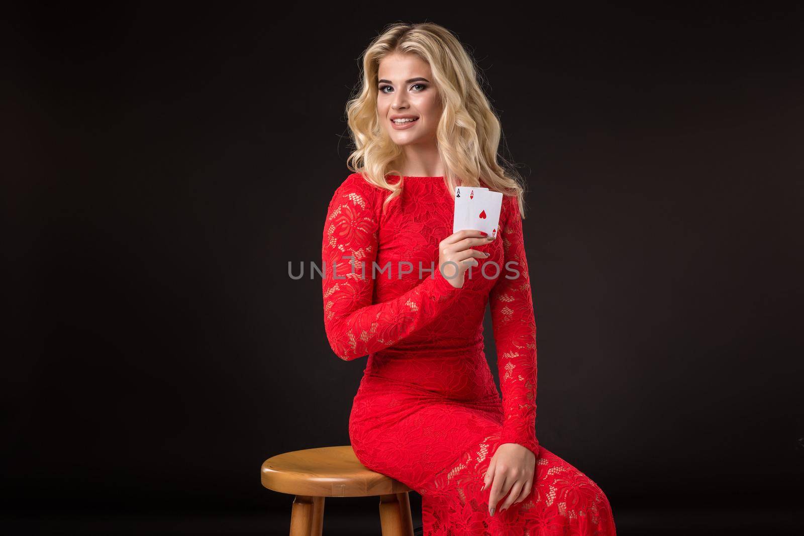 Young woman in casino with cards over black background. Poker by nazarovsergey