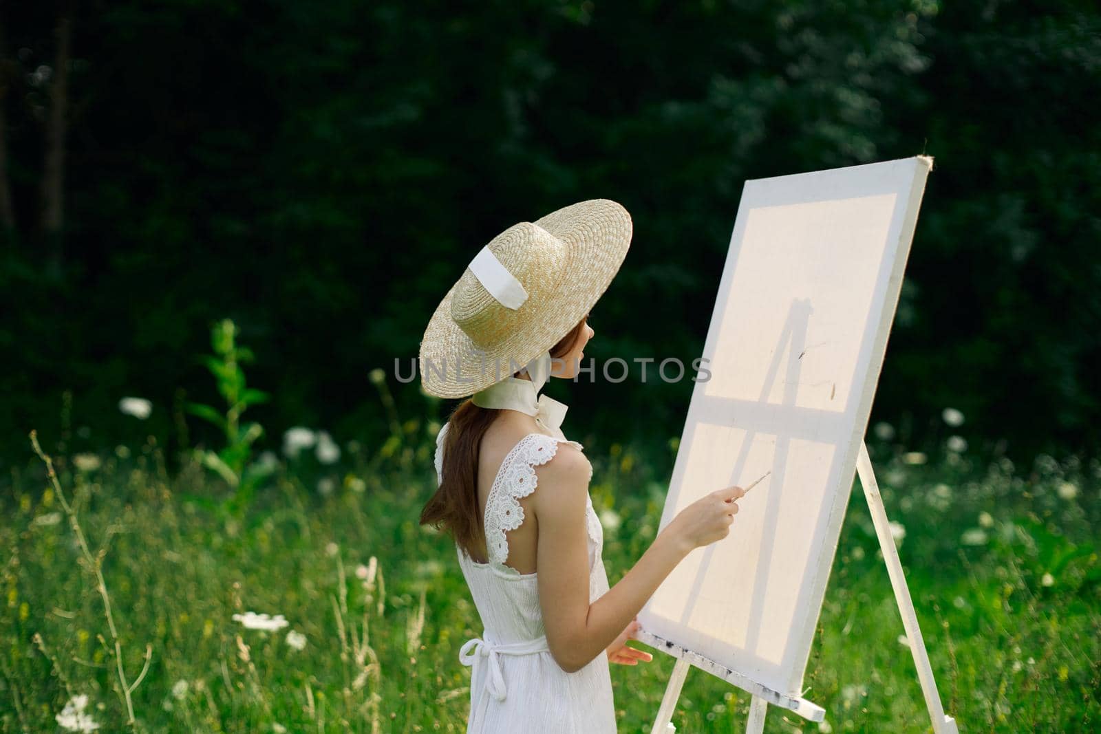 Woman in white dress in nature paints a picture of a landscape hobby by Vichizh