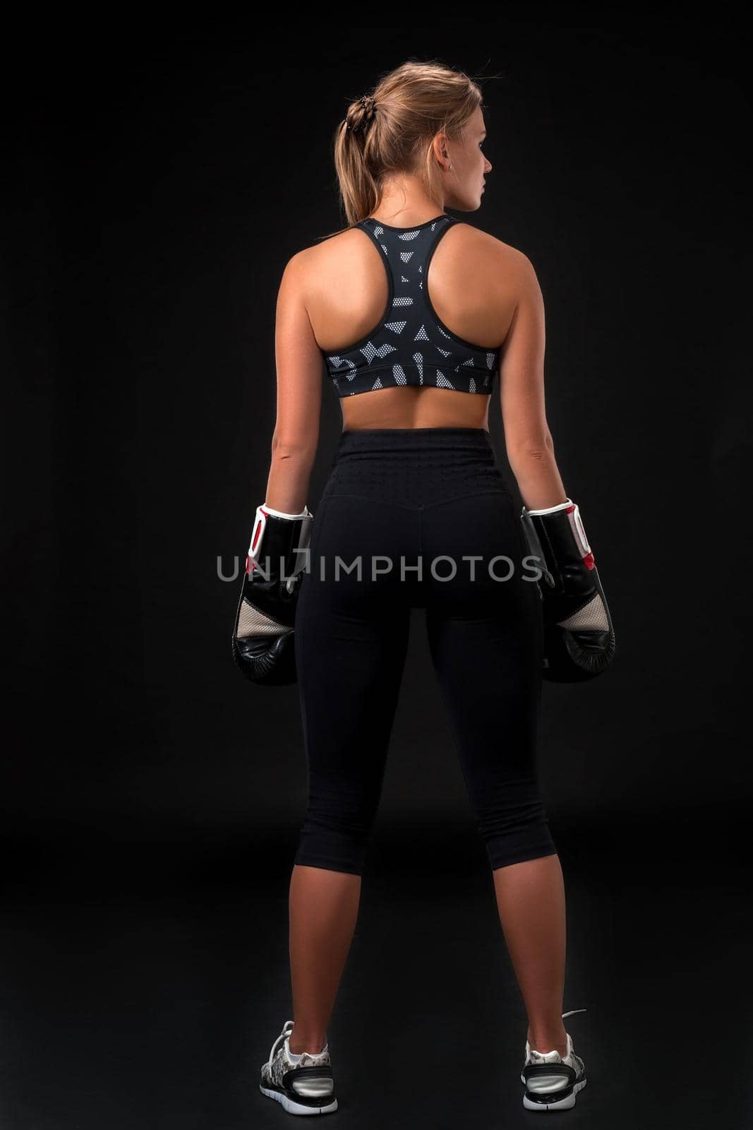 Young woman wearing boxer gloves back view by nazarovsergey