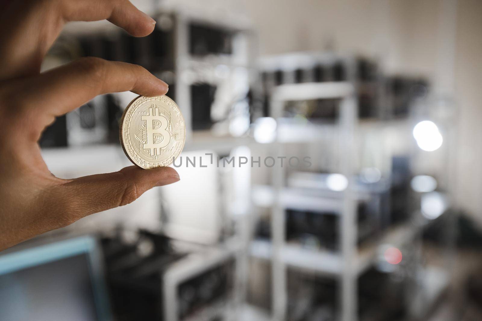 In hand is a gold coin bitcoin on a farm