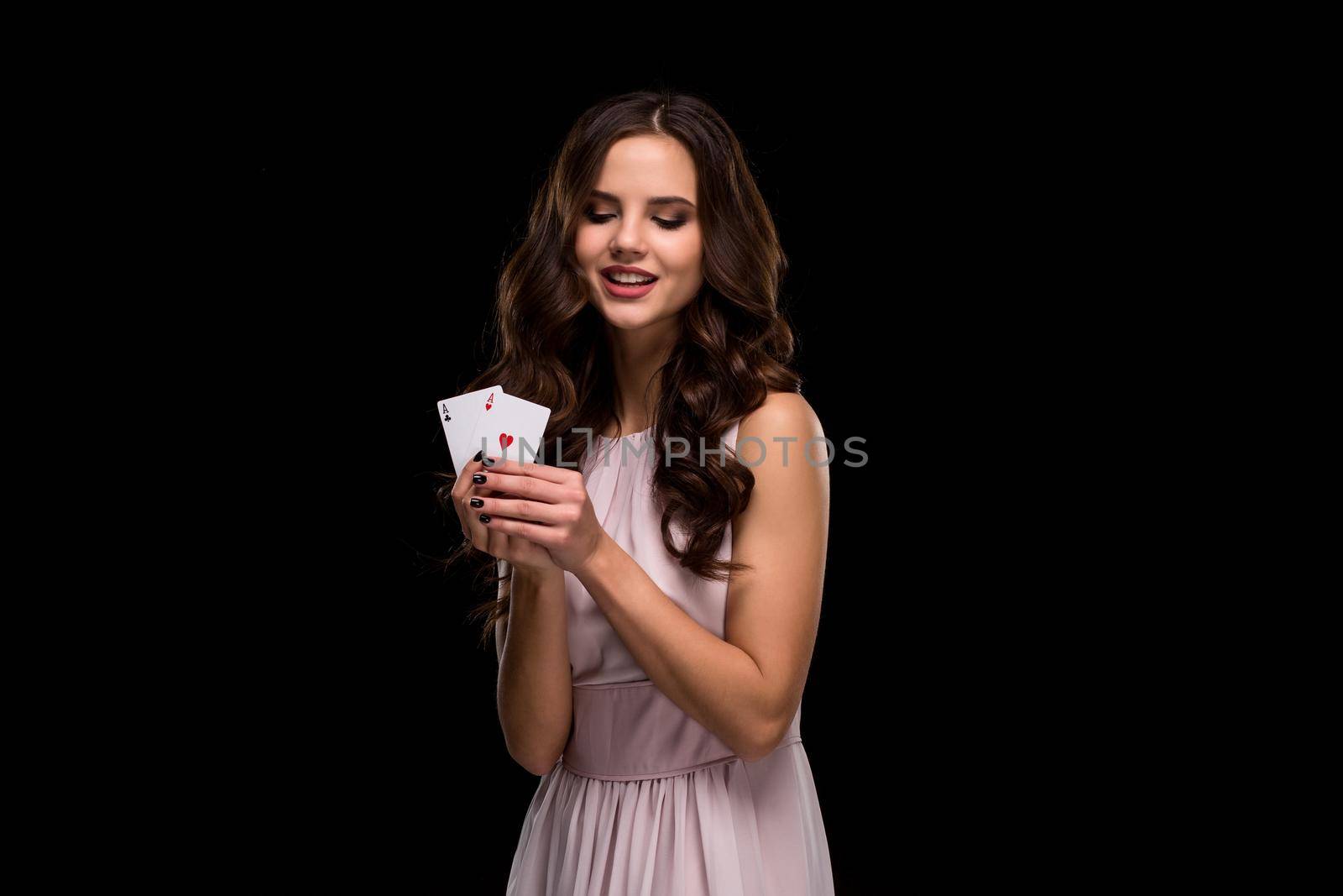 Sexy curly hair brunette posing with casino cards two aces in her hands, poker concept black background. Casino, poker, Roulette Blackjack Spin. Big win. winning combination