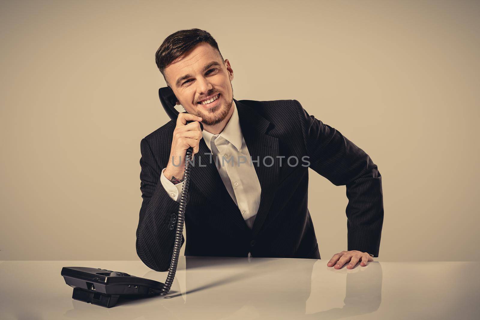 young man dials the phone number while sitting in the office by nazarovsergey