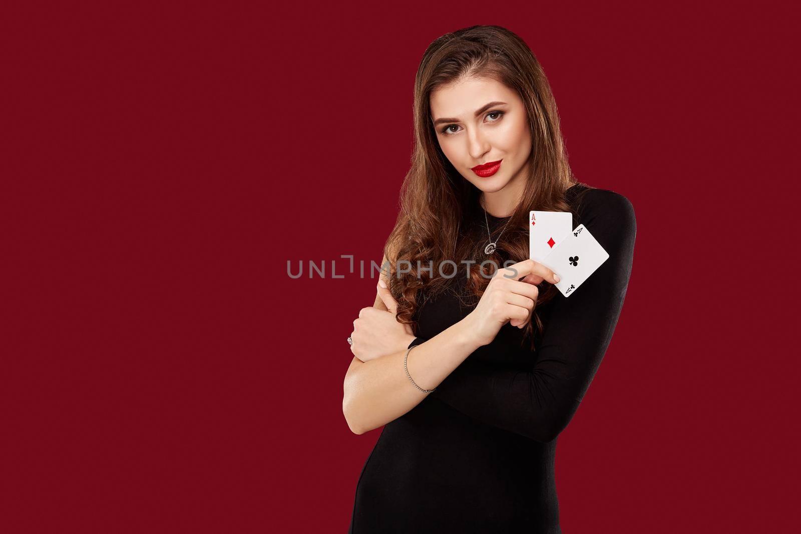 Beautiful caucasian woman in black dress with poker cards gambling in casino by nazarovsergey