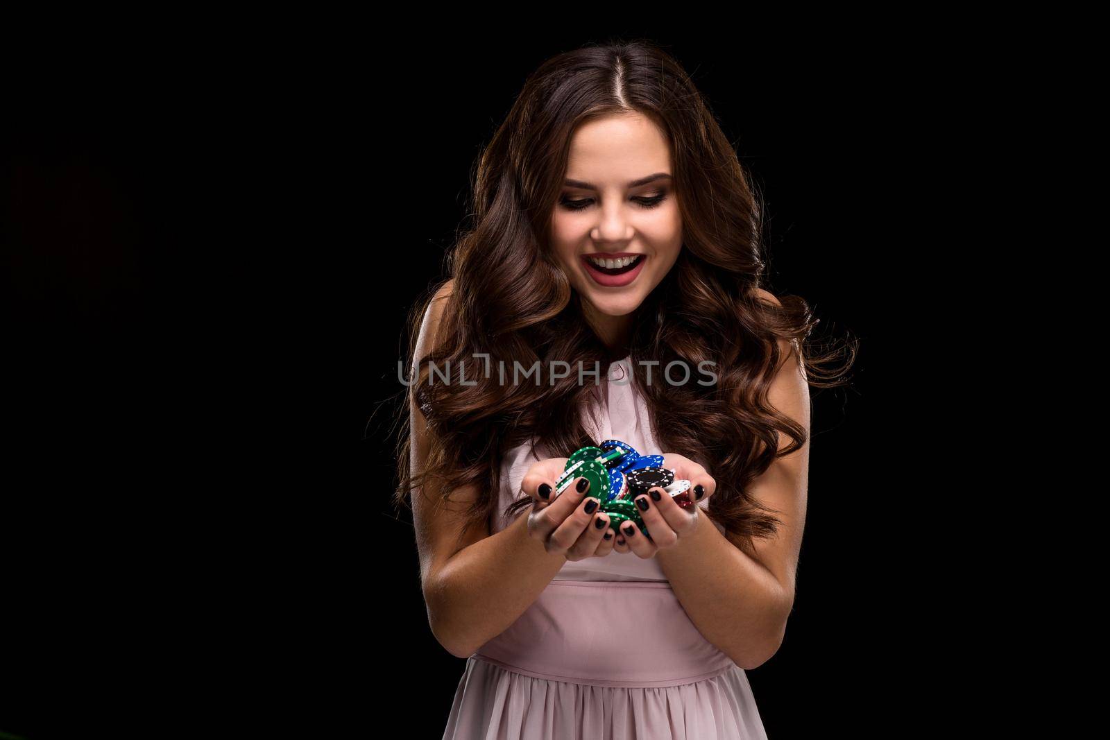 Sexy curly hair brunette posing with chips in her hands, poker concept black background. Casino, poker, Roulette Blackjack Spin. big win emotions