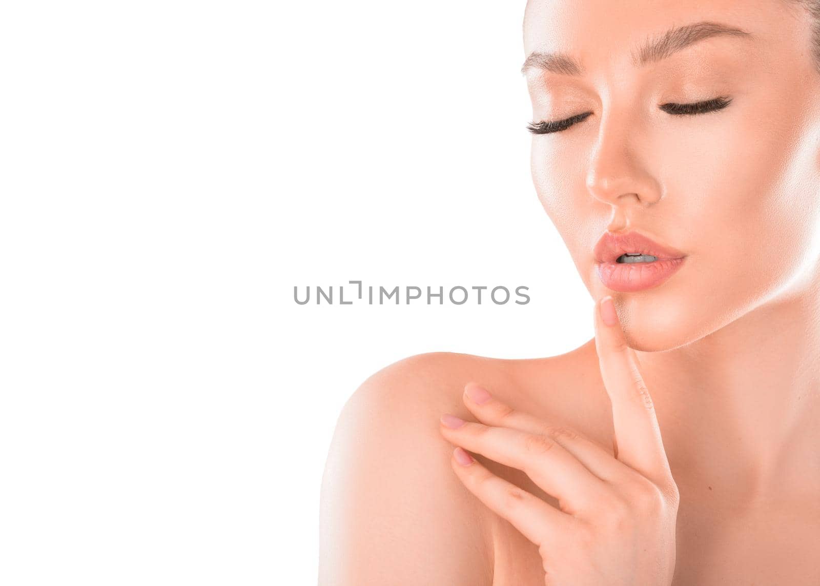 Close up portrait of a beautiful young woman with closed eyes over white background. Skin care concept.