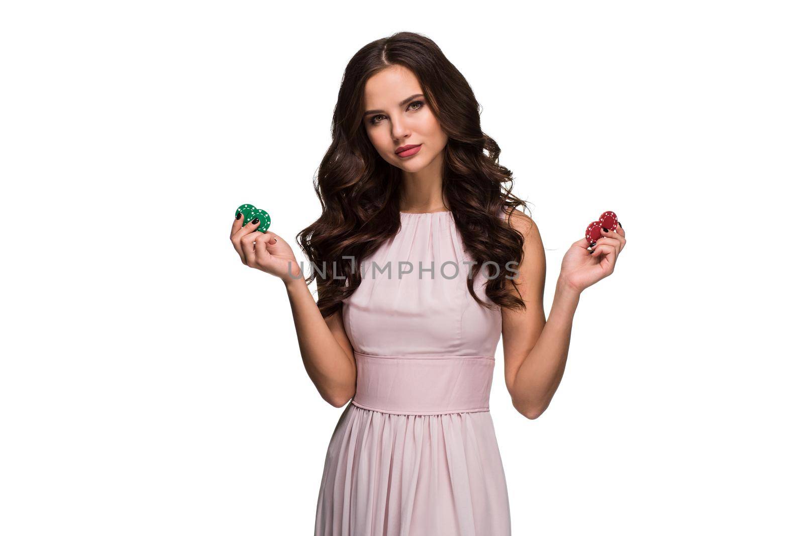 Sexy woman in a chic gently pink dress holding colored poker chips. Woman winning by nazarovsergey