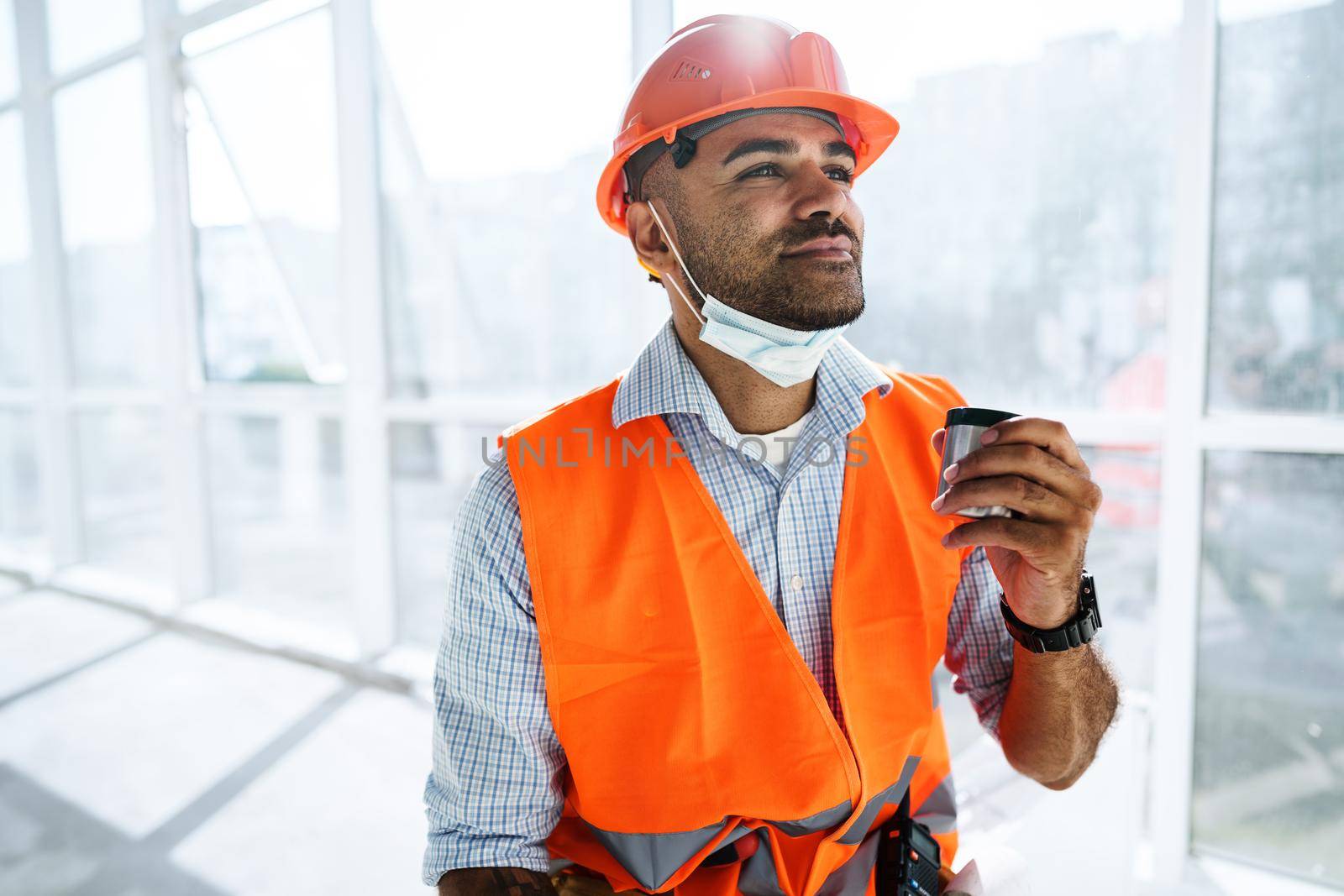 Portrait of a man worker in workwear on a break drink coffee and have rest, close up