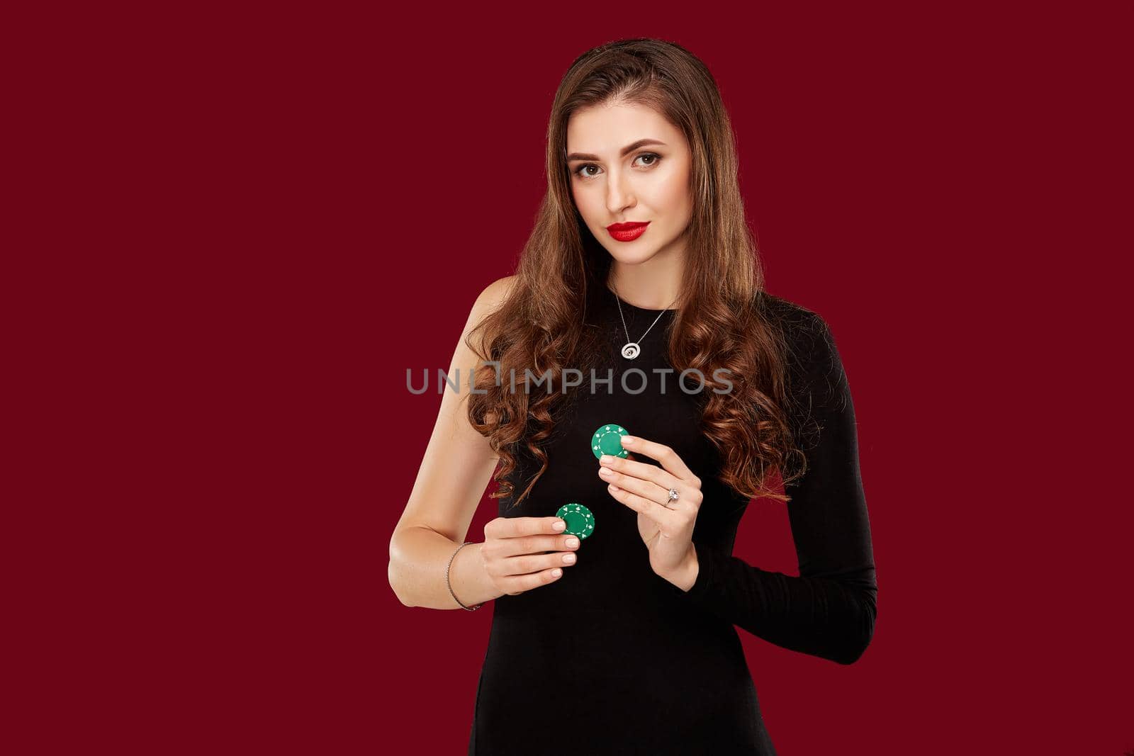 Pretty long hair woman in black dress holding chips for gambling by nazarovsergey