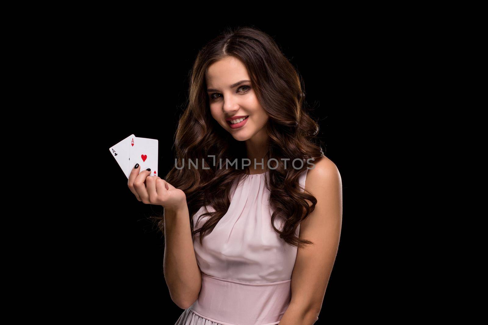 Sexy curly hair brunette posing with casino cards two aces in her hands, poker concept black background. Casino, poker, Roulette Blackjack Spin. Big win. winning combination