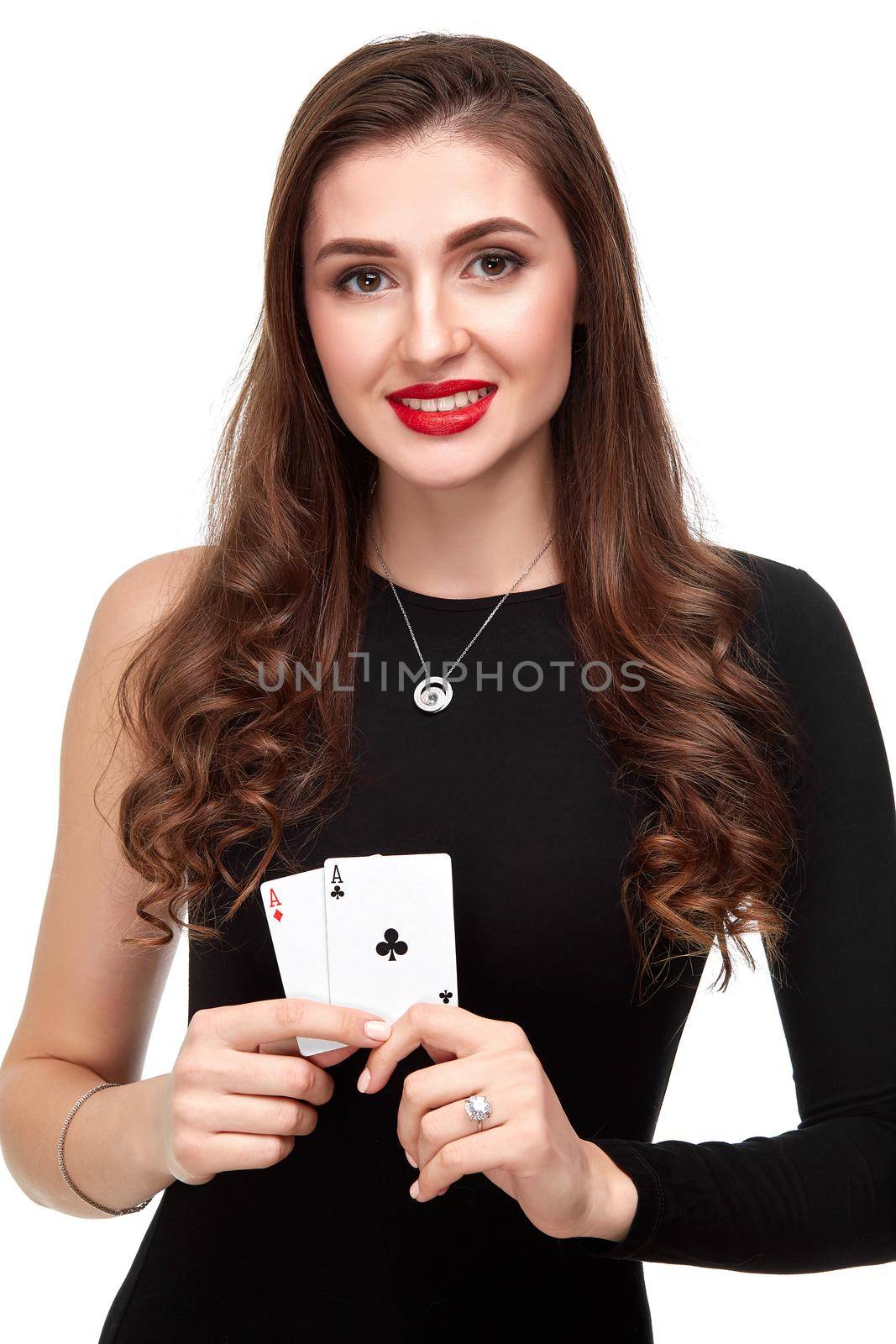 Sexy curly hair brunette in black dress posing with two aces cards in her hands, poker concept isolation on white background. winning combination