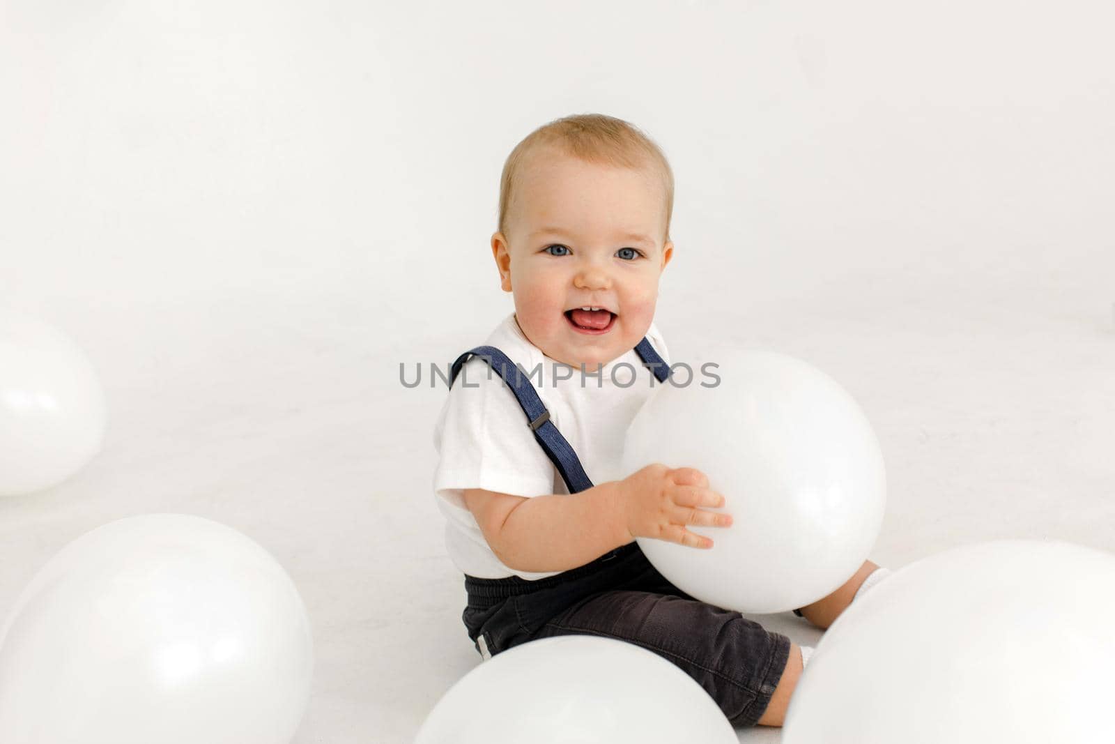 Joyful little kid with balloons in studio by Demkat