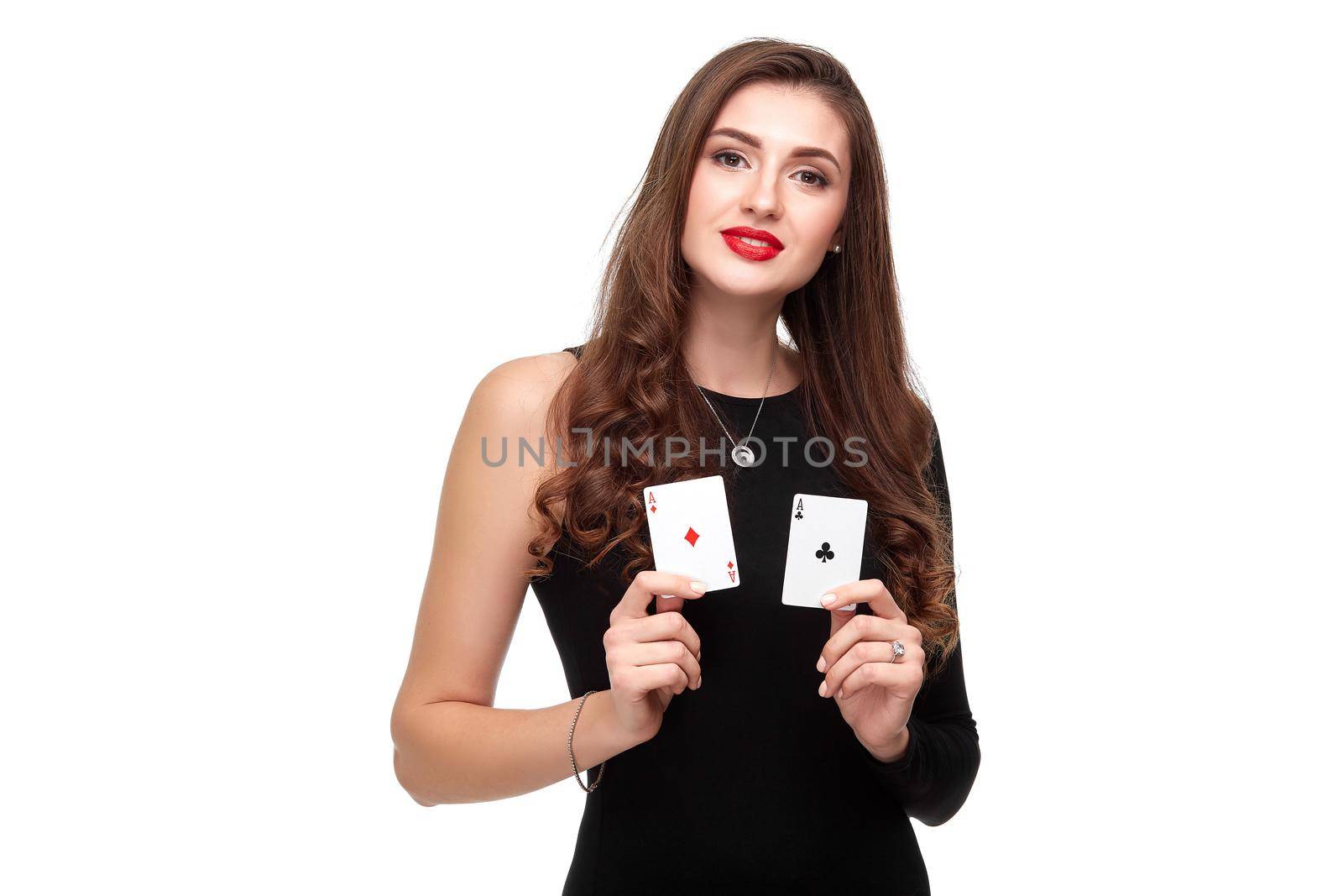 Sexy curly hair brunette in black dress posing with two aces cards in her hands, poker concept isolation on white background. winning combination