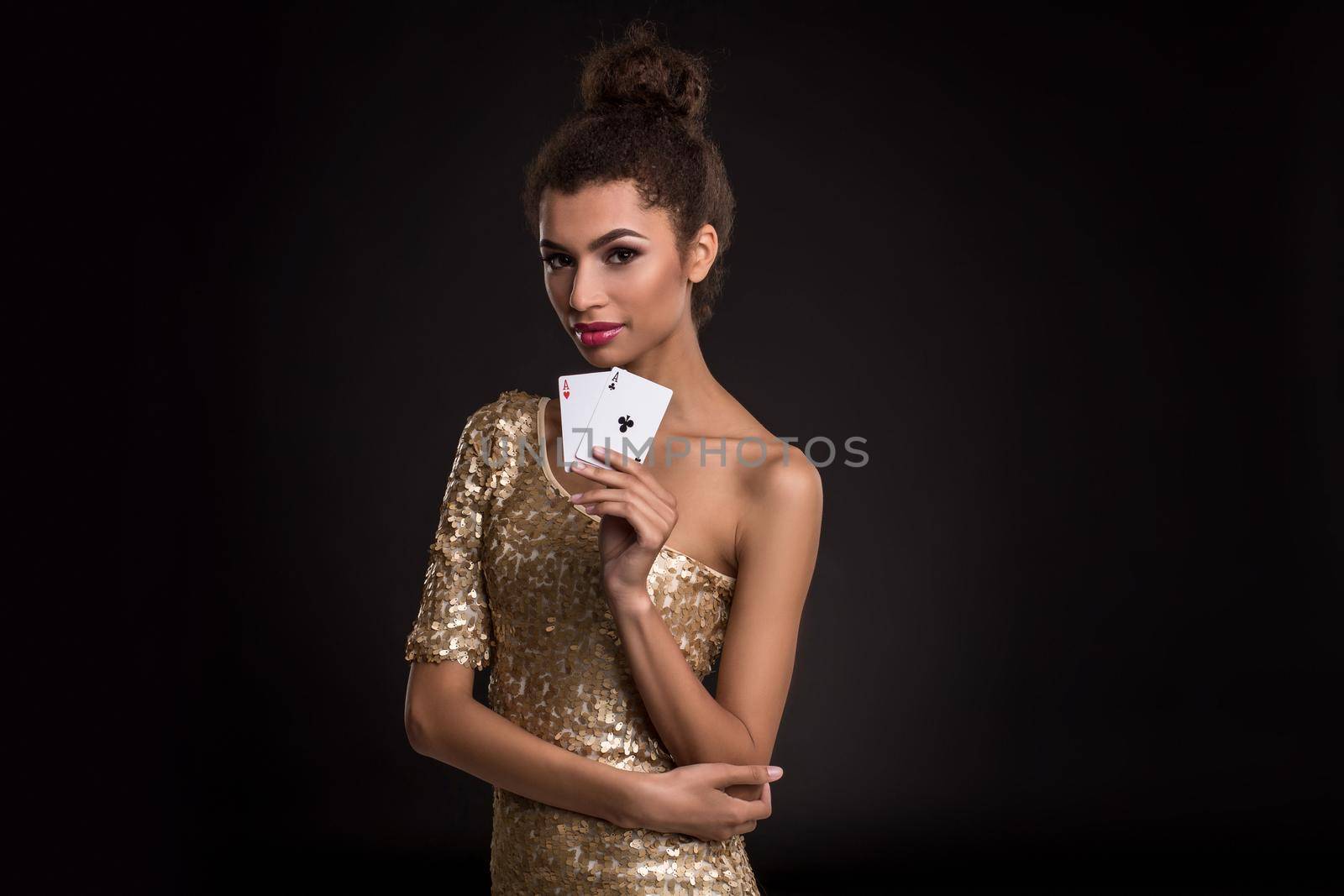 Woman winning - Young woman in a classy gold dress holding two aces, a poker of aces card combination. by nazarovsergey