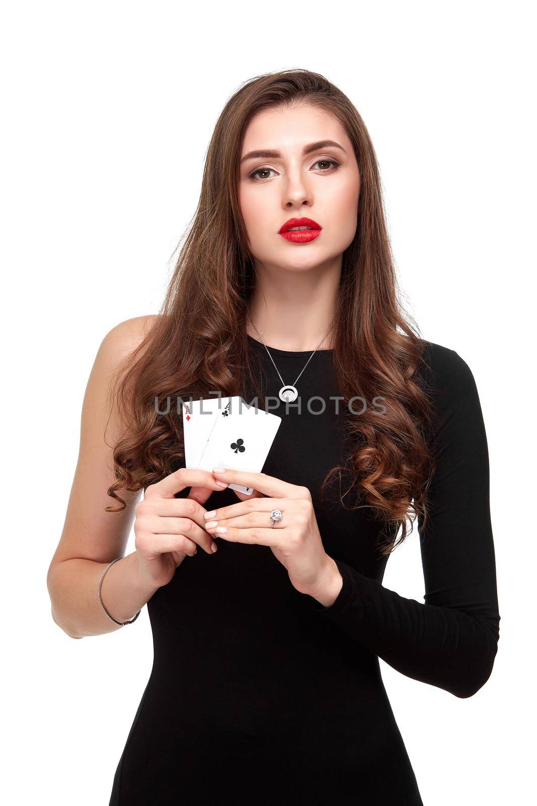 Sexy curly hair brunette in black dress posing with two aces cards in her hands, poker concept isolation on white background. winning combination