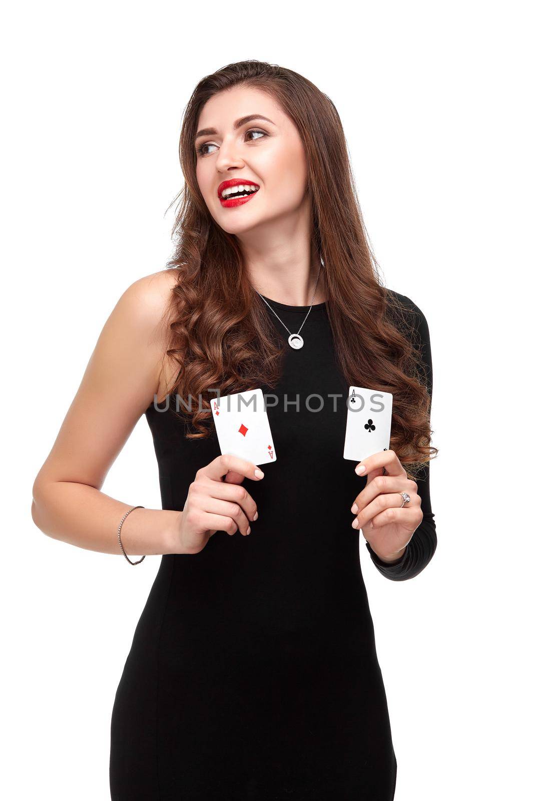 Sexy curly hair brunette in black dress posing with two aces cards in her hands, poker concept isolation on white background. winning combination