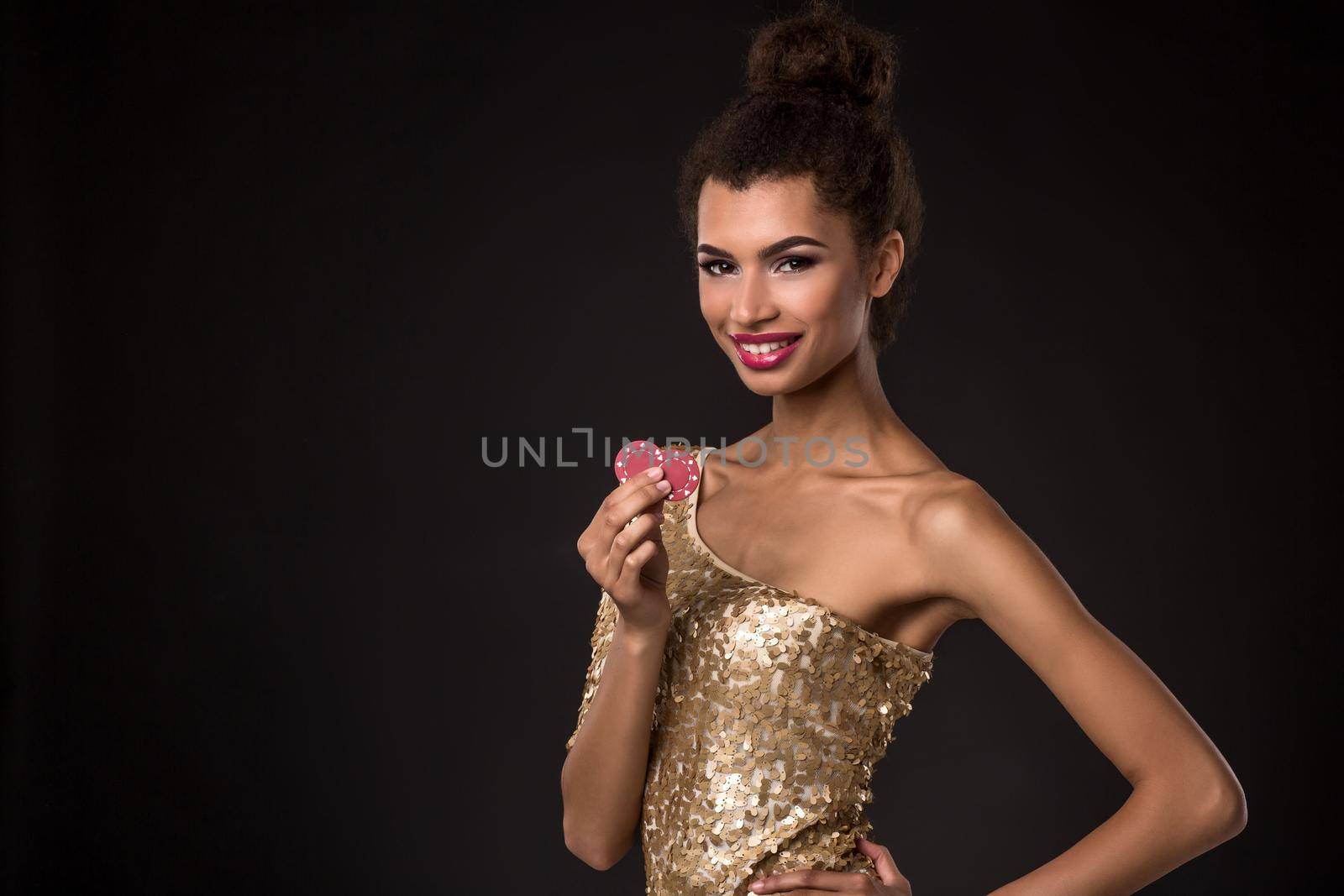 Woman winning - Young woman in a classy gold dress holding two red chips, a poker of aces card combination. by nazarovsergey