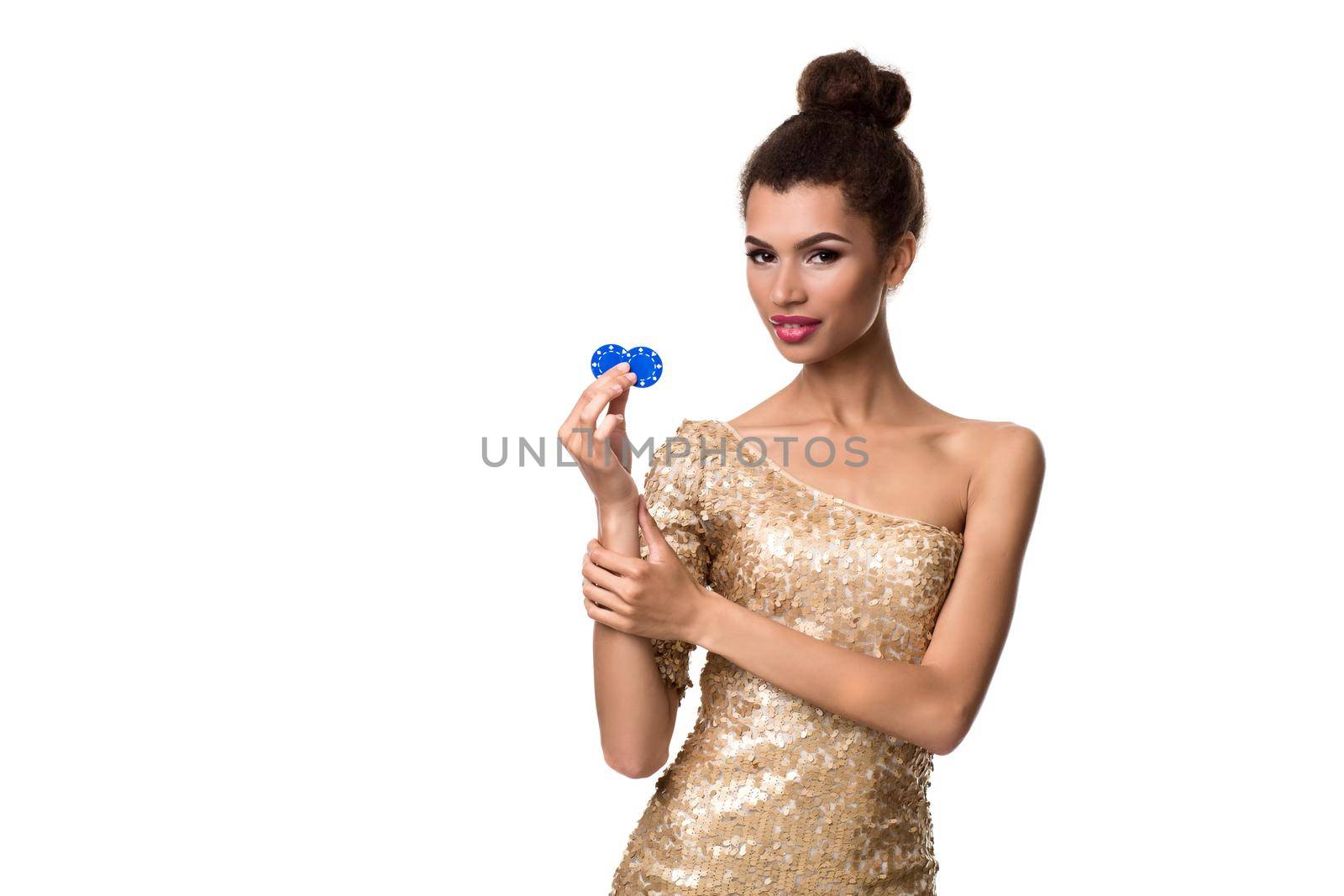 Smiling young woman holding two chips in her hands. Woman in gold dress is isolated on white background