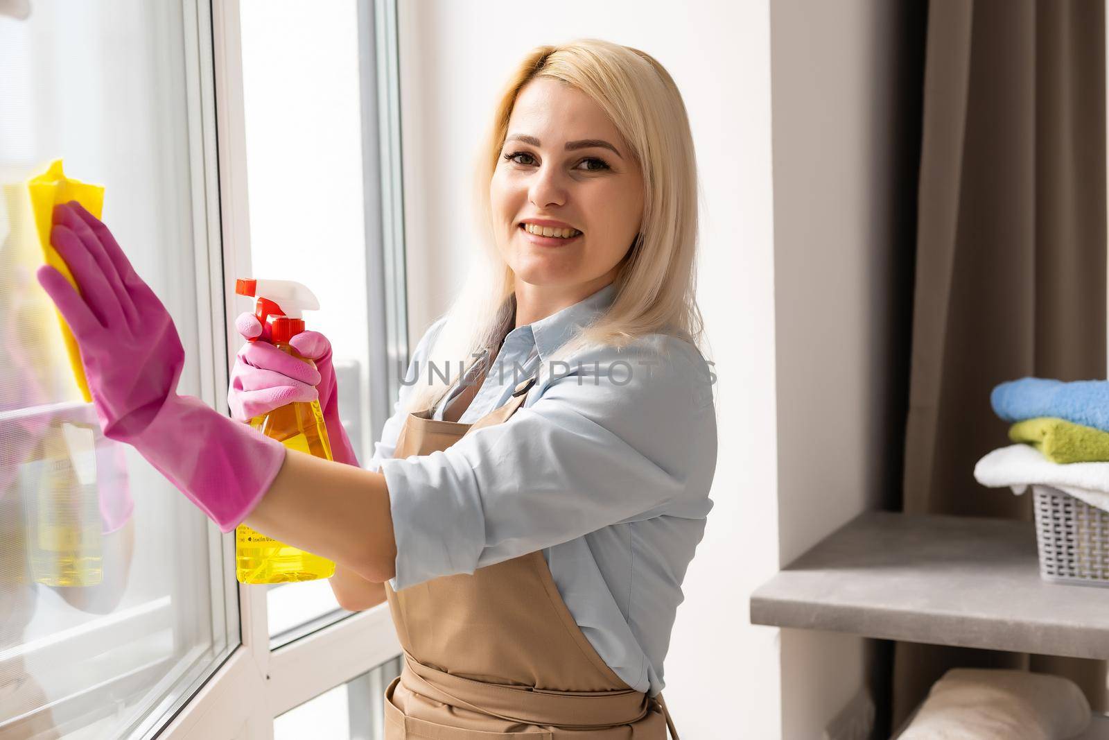 Young woman cleaning the window by Andelov13