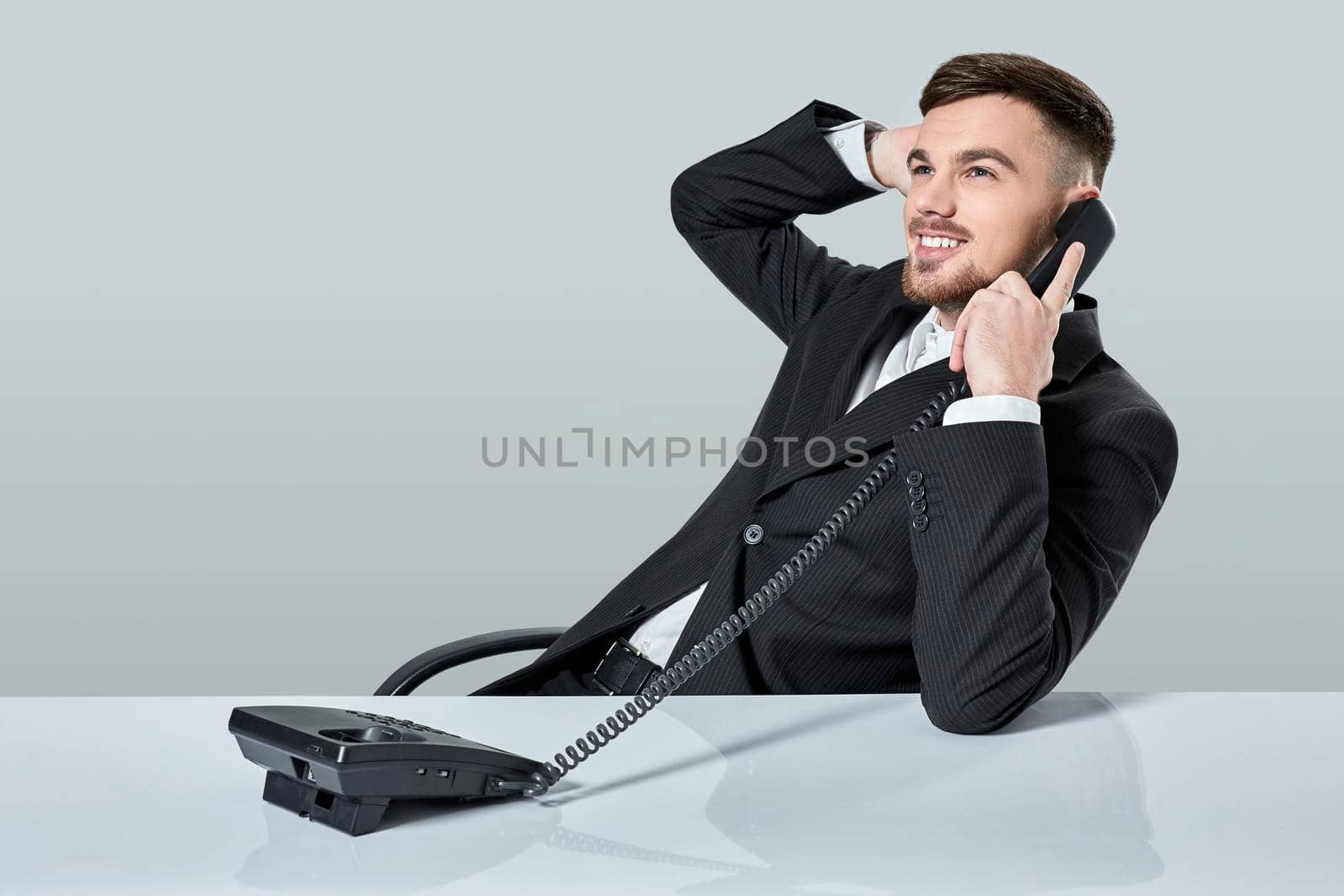 young man dials the phone number while sitting in the office by nazarovsergey