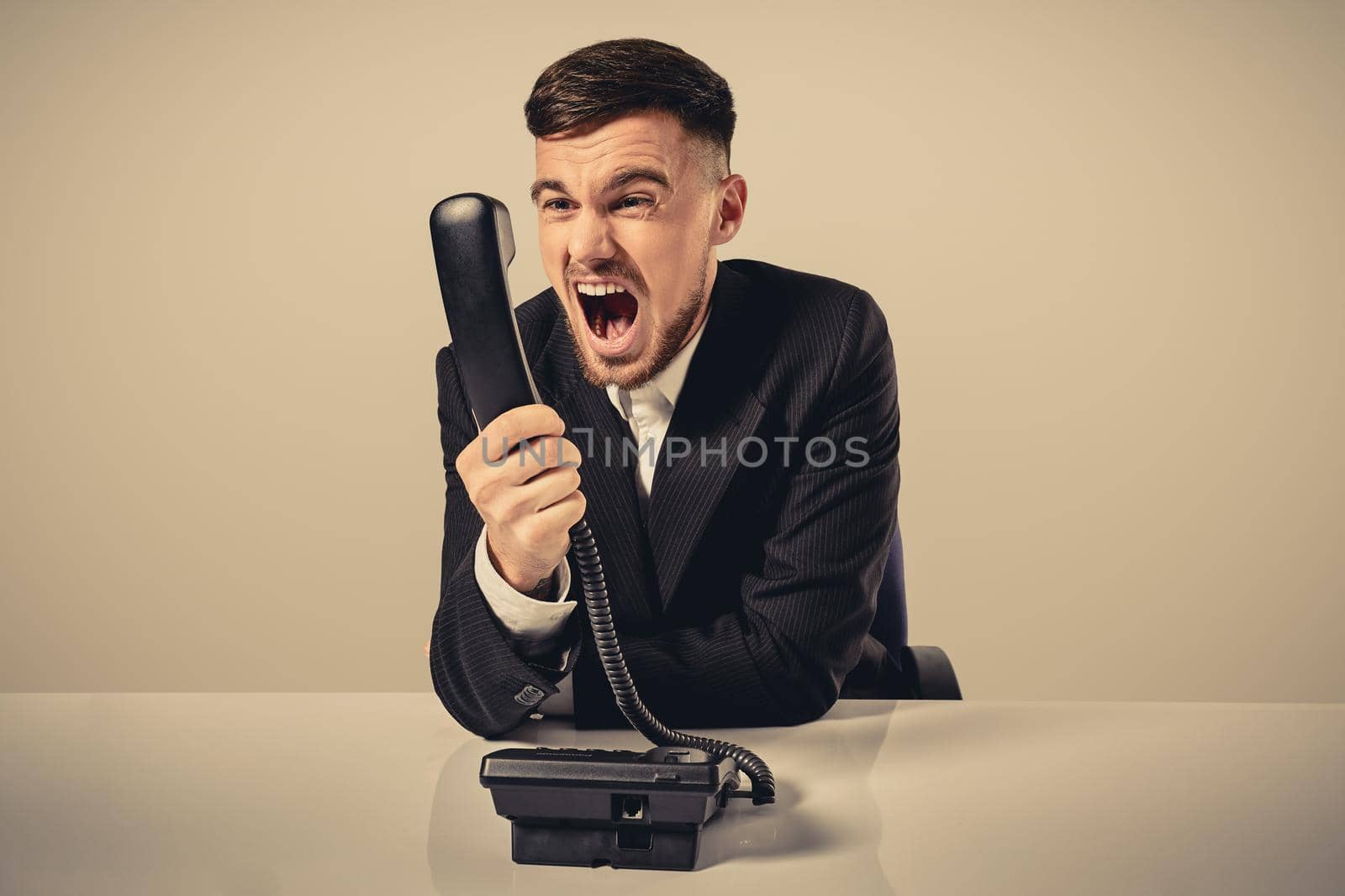 young man dials the phone number while sitting in the office by nazarovsergey