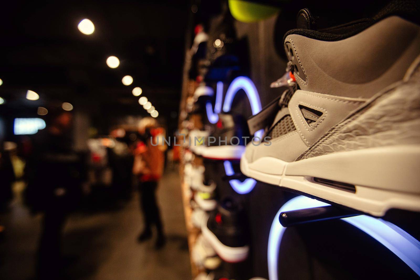 White sneakers on street window of night city decorated with illumination and neon lights